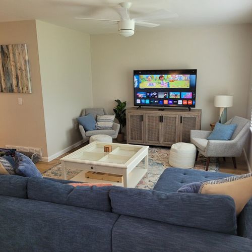 Living room:  the living room features a cozy sectional that unfolds into a double bed. There is also a coffee table, hutch, ceiling fan, a couple portable chairs, a dog bed, and a large smart tv.