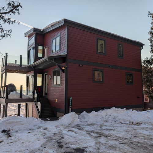 EXTERIOR:  The front of the home in winter, highlighting the multiple decks with Crystal Lake in the background.