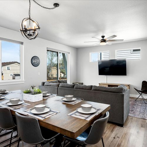 - open concept dining and living area perfect for large groups and shared experiences
- long wooden table and cushioned seating flow into a cozy lounge with tv
- natural light and clean design make it easy to relax, dine, and connect