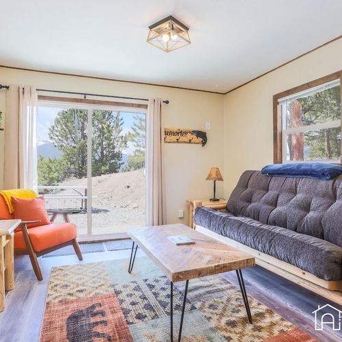 Living room with cozy, rustic furnishings and a mounted 43” widescreen smarttv.