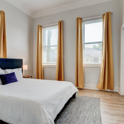 Bright queen bedroom w/ natural light & warm tones — a cozy first bedroom to recharge.