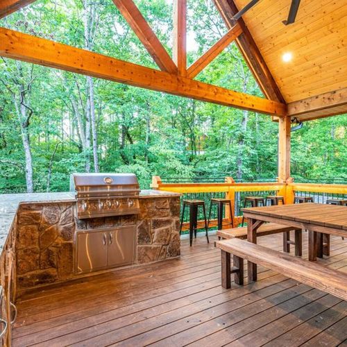 Built-in outdoor kitchen complete with a sink, grill, and trash facilities