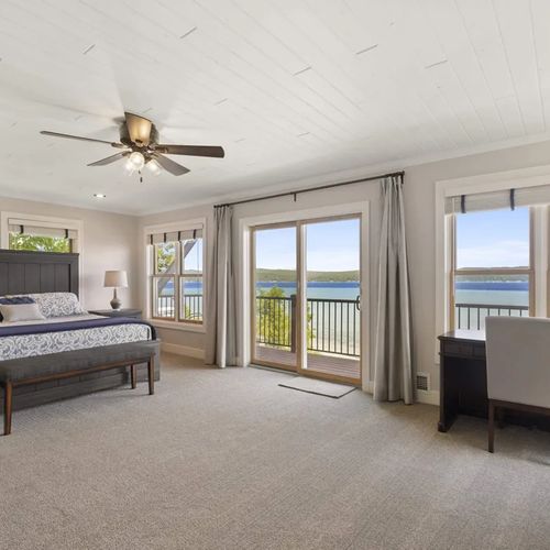 PRIMARY BEDROOM (UPPER LEVEL):  The home has a truly spectacular primary bedroom on the upper level with a king-size bed, private balcony, incredible view of Crystal Lake, private ensuite bathroom, gas fireplace, and private television.