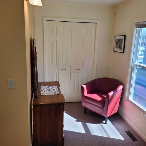 BEDROOM #1:  Features a queen-size bed, dresser, closet, and chair.