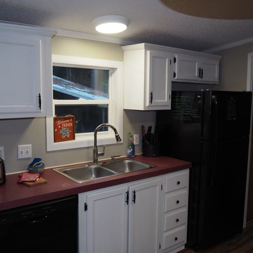 The kitchen from another angle, highlighting the kitchen sink, dishwasher, toaster, and refrigerator.