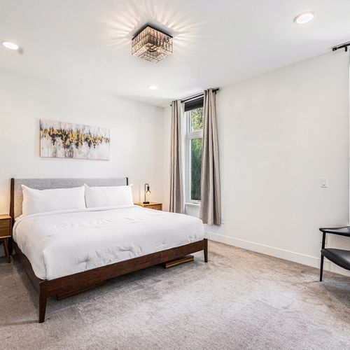 Bright and serene, this bedroom blends soft textures with artistic decor and warm-toned highlights.