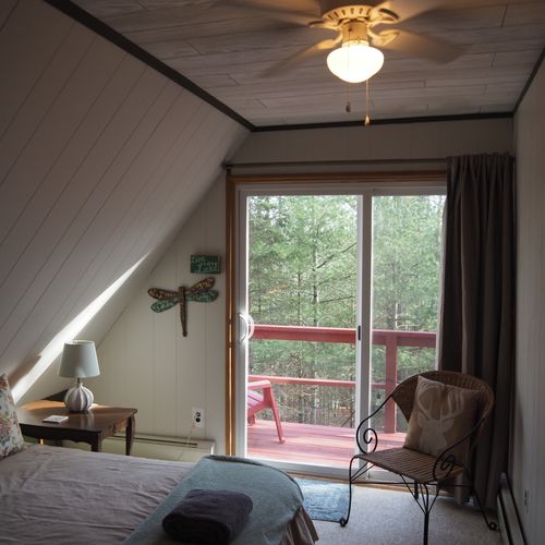 Bedroom #2 (second floor):  features a queen-size bed, walk-out balcony with lakeview, nightstands with lamps, ceiling fan, and a closet.