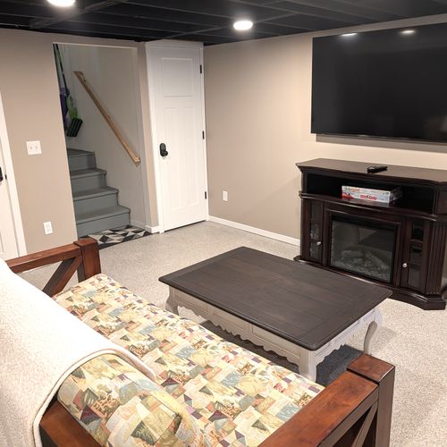 LIVING ROOM #3 (LOWER LEVEL):  Very fun third living room / game room in the basement with a futon, loveseat, coffee table, electric fireplace, and large screen smart television with live streaming. Note that this room is not to be used for sleeping.