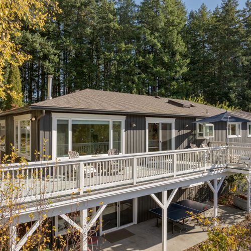 Wraparound deck nestled among evergreens—perfect for morning coffee, outdoor dining, or unwinding with forest views and fresh air.