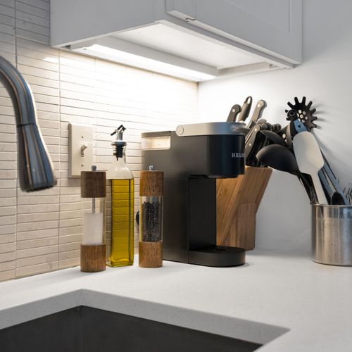 Compact kitchen w/ everything you need, tucked behind an exposed brick wall.