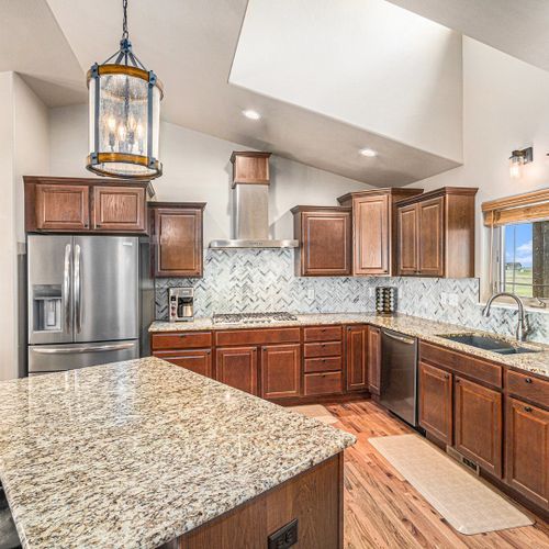 A modern kitchen with stainless steel appliances and a sleek granite countertop, perfect for preparing your favorite meals, just like at home.