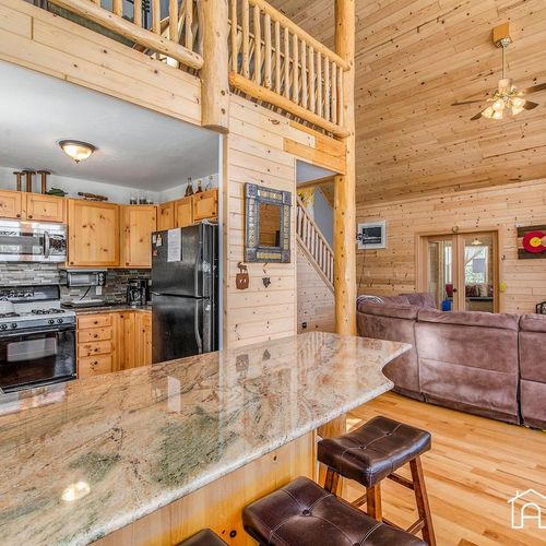 - granite countertops lead into a spacious lounge with high ceilings and soft lighting
- perfect blend of modern kitchen convenience and cozy cabin charm in one open space
- ideal for entertaining, relaxing, or sharing meals with the whole group