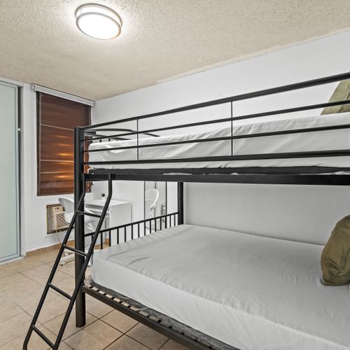 Efficient and stylish, this room offers a comfortable sleeping arrangement with its chic black bunk beds and spacious layout.