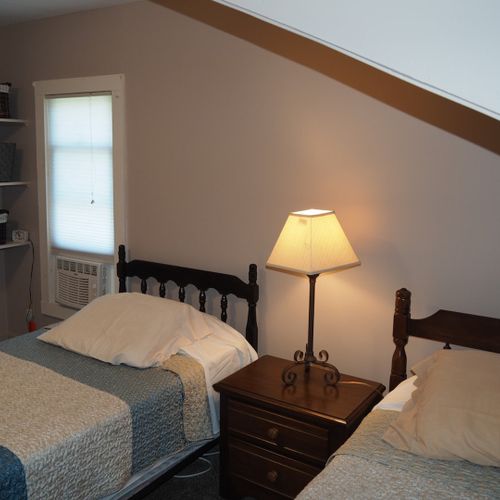 Bedroom #2:  features 2 twin beds, window a/c unit, nightstand, lamp, and mirror.