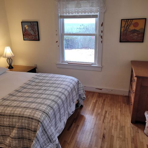 Bedroom #1 (main floor):  features a full-size bed, table, chair, dresser, and closet.