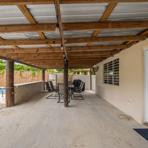 Spacious covered patio by the sparkling pool.