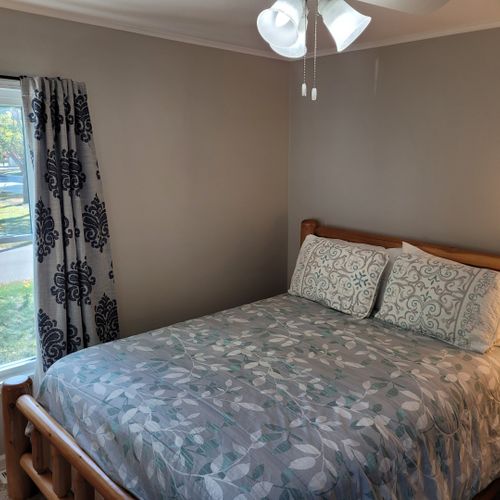 Bedroom #1:  features a queen-size bed, ceiling fan, nightstand, lamp, closet, and dresser.
