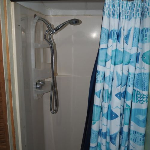 Bathroom:  very cute little bathroom with a sink, vanity, mirror, toilet, shower, and chair.