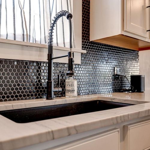 Bold mosaic backsplash adds a stylish touch to the kitchen.