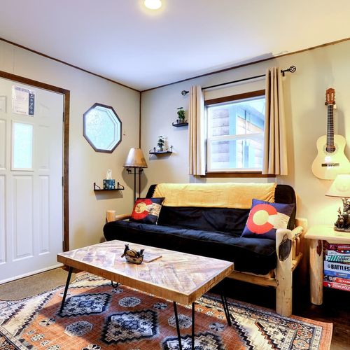 - enjoy rustic vibes with handcrafted wood furniture and guitar wall décor
- decorative pillows and throw blanket give this living space a cozy flair
- curl up with a book or unwind with your favorite tunes in mountain style