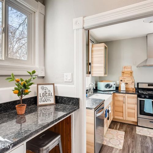 - cozy breakfast nook features granite counter, bar stool seating, and sunny window views
- cute farmhouse sign and small citrus plant add charm and personality
- tucked just off the main kitchen area for a quiet morning coffee retreat