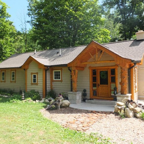 Exterior:  a broader view of the front of the house, with the exterior wood fireplace still visible.
