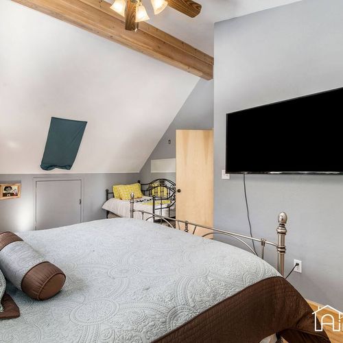 - spacious sleeping area with king bed and extra twin tucked beneath sloped wood beams
- wall mounted tv and cozy bedding make it ideal for families or small groups
- rustic charm meets comfort with vaulted ceilings and modern decor
