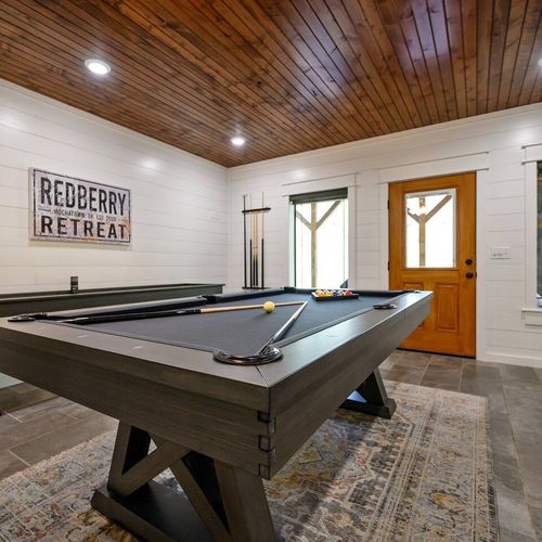 Equipped with a pool table, shuffleboard and outdoor patio access.