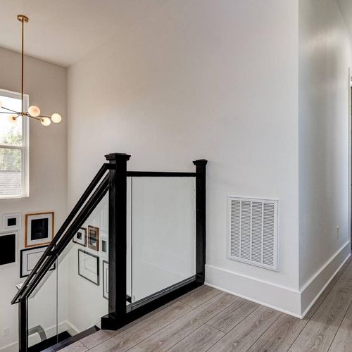 Elegant staircase w/ dark wood railings & open, airy feel.