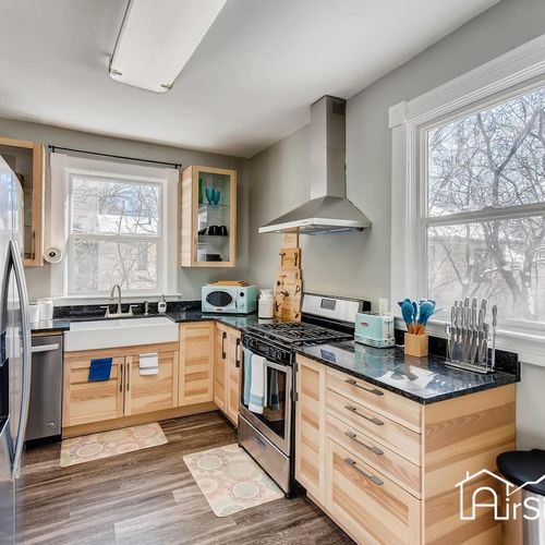 - sleek kitchen with two tone cabinets, granite counters, and a deep farmhouse sink
- stainless appliances and open shelving make cooking easy and stylish
- large windows keep the space bright and inviting all day