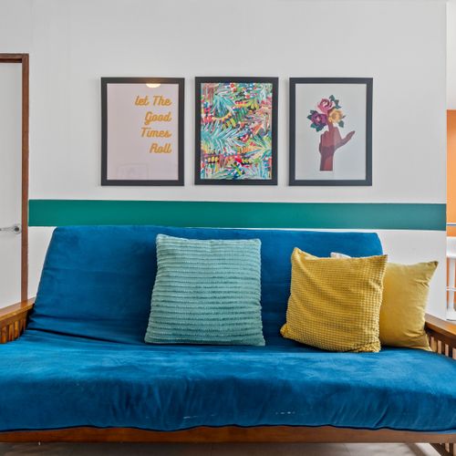 Step into a vibrant and eclectic living space with a cozy blue sofa.