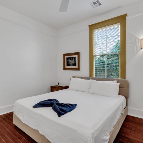 Serene bedroom w/ natural window light & crisp, clean linens.