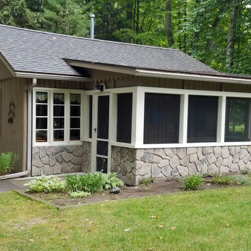 Overall:  the front of the cabin, highlighting the screened-in front porch