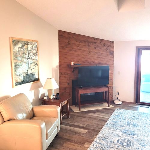 LIVING ROOM:  The home has a comfy living room with a wood fireplace.  (The television is now above the fireplace mantle.)  Note that the sliding doors lead out to the sunroom.