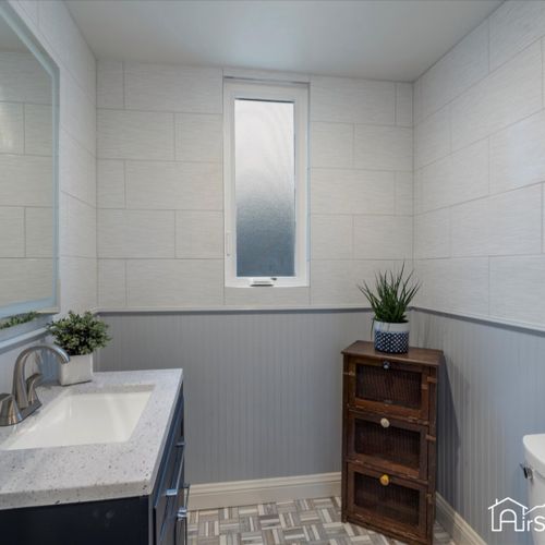 The basement hallway bathroom features a full bath with a convenient shower-tub combo, combining functionality with comfort.