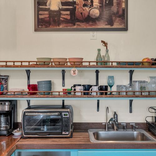 Well-stocked open shelving kitchen w/ everything you need within reach.
