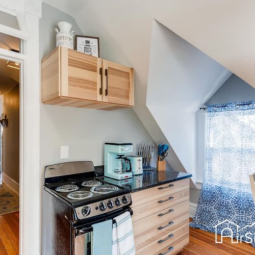 - unique kitchenette with angled ceiling, mini oven, coffee maker, and open cabinetry
- tucked beneath a dormer window, the space feels bright and efficiently designed
- ideal for prepping coffee, quick meals, or snacks upstairs