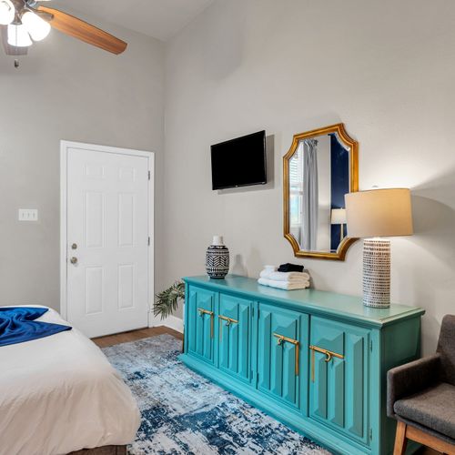 Teal entryway console w/ a mirror & warm lamp — a stylish first impression.