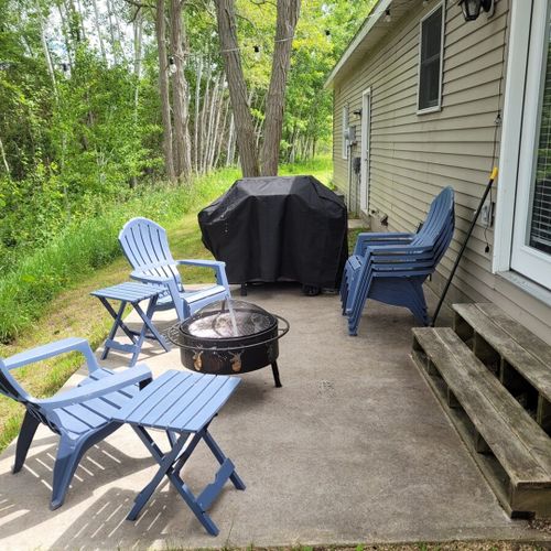 Exterior:  the backyard, which faces the river and features a gas grill, outdoor bonfire ring, adirondack chairs, and small tables.