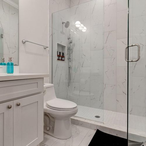 Ensuite master bath w/ a sleek tiled shower & modern finishes.