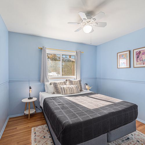 Snuggle up in fresh linens and plush pillows on this comfortable queen bed in the upstairs bedroom.