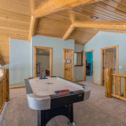 Experience leisure and breathtaking views from the loft game room, framed by floor-to-ceiling windows offering unparalleled vistas.