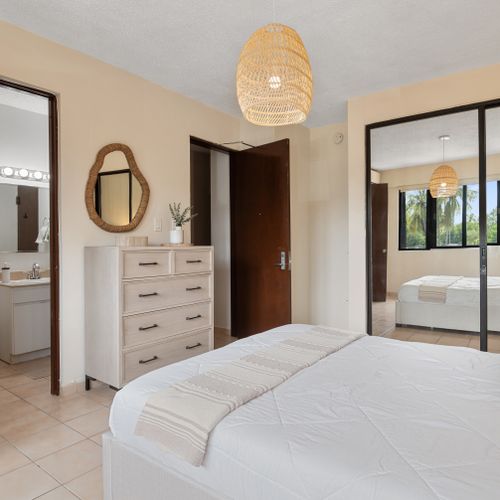 Your serene sanctuary awaits! Enjoy comfort and style in the master bedroom, connecting you to the tropical outdoors.