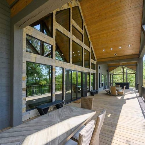 The wrap around porch has dining tables, a kitchen, couches and more!