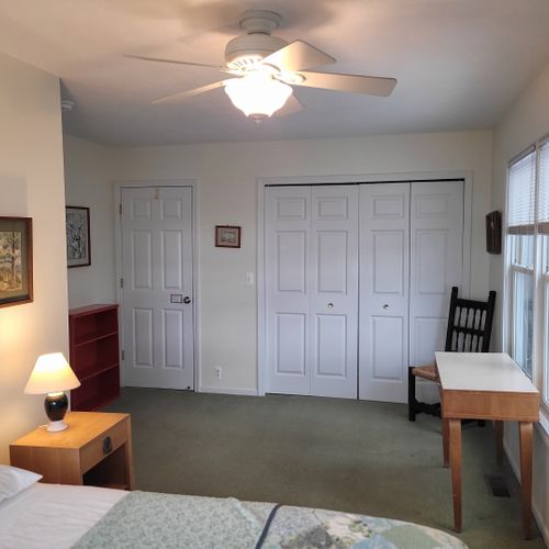 Bedroom #4 (upper level):  very large bedroom featuring a queen-size bed, credenza, ceiling fan, closet, chair, and great views of lake michigan!