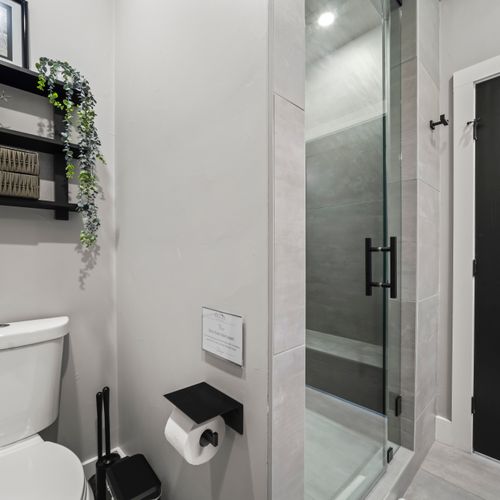 Modern bathroom featuring glass-enclosed walk-in shower and clean design.