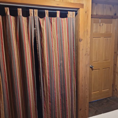 Bedroom #2 (main floor):  features a queen-size bed, portable a/c unit, closet, and drawers.