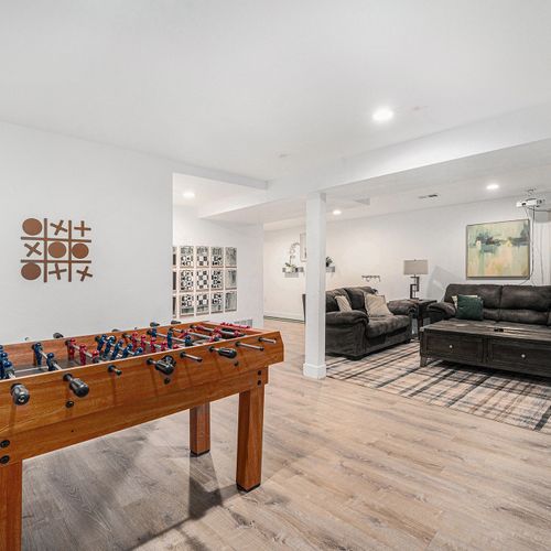 The lower-level living space offers ample seating for larger gatherings along with an 100" screen and projector, making the basement the perfect retreat for relaxation and socializing.