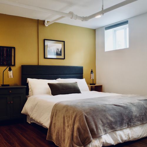 Comfortable queen bed in the fourth bedroom, with airy windows and blackout shades for nighttime comfort.