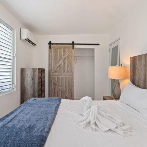 A peaceful chamber with a large bed and a rustic sliding panel.